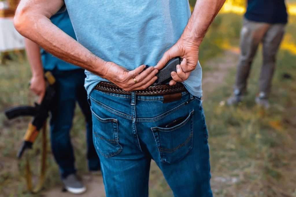 Un hombre con una pistola metida en la parte trasera de los jeans