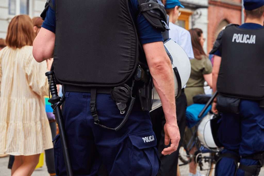 Agentes de policía con chalecos entre una multitud en una calle de la ciudad