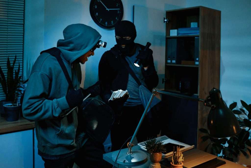 Dos ladrones enmascarados registrando una oficina de noche