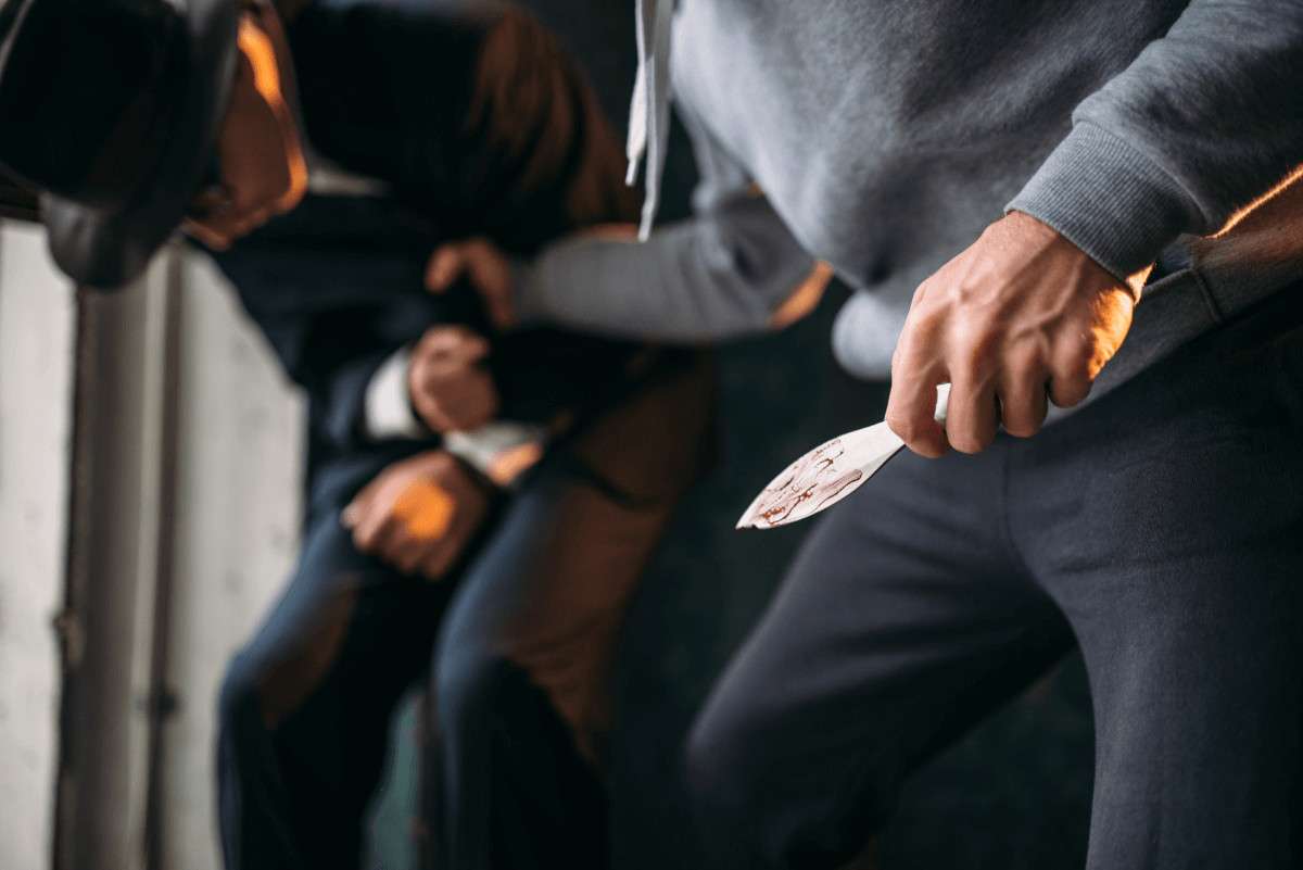 Dos hombres forcejeando, uno de ellos con un cuchillo