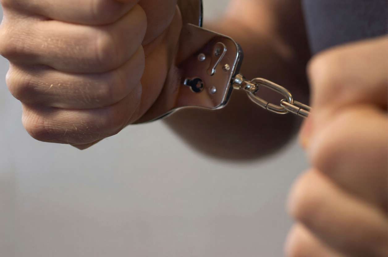 Primer plano de una mano tirando de unas esposas